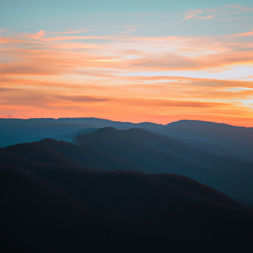 a photo of a mountain range with a sunset in the background